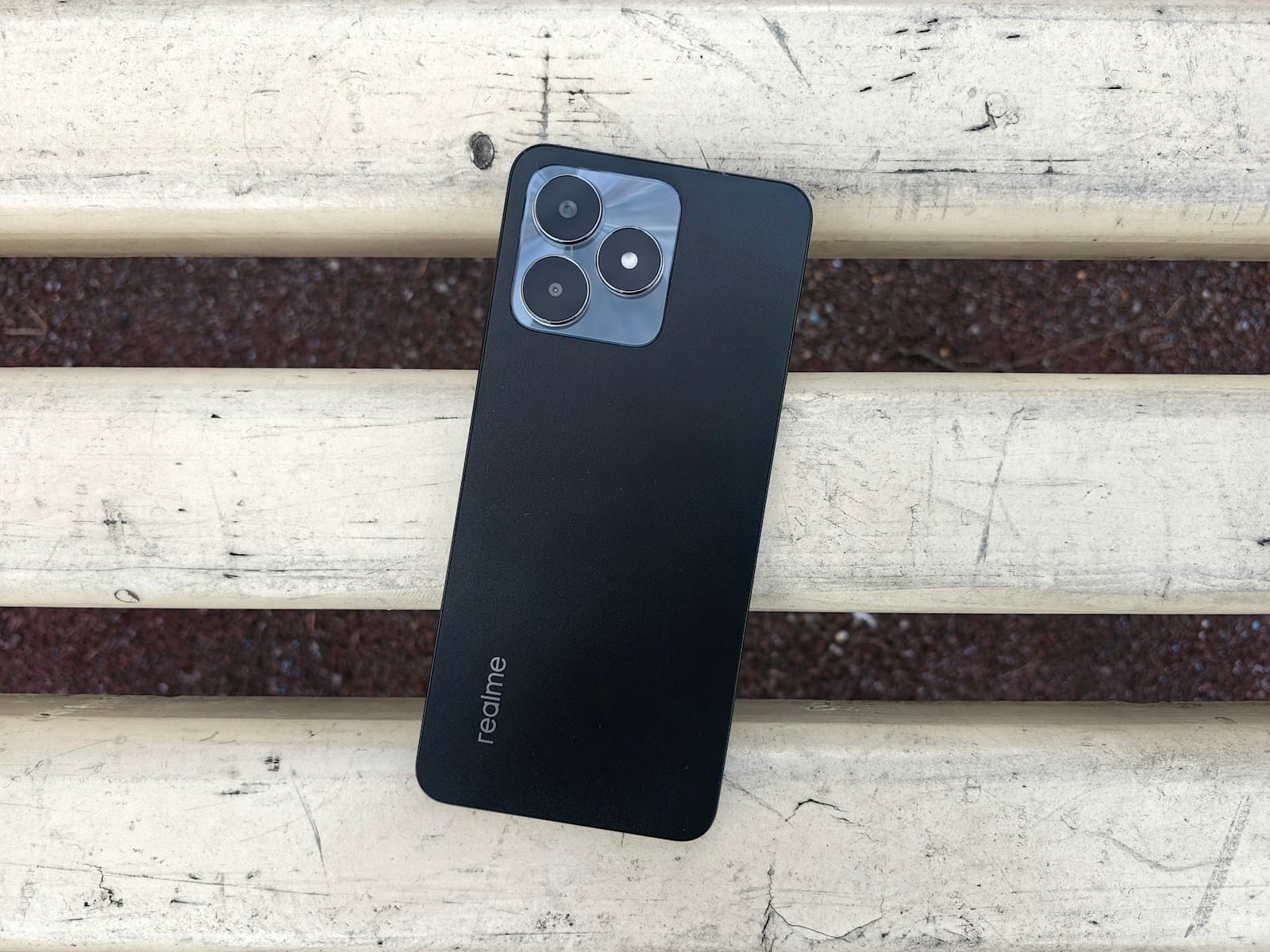古い木のベンチの上に置かれた、黒いスマートフォン